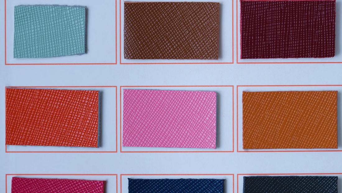  The leather has a fine, cross-hatched pattern, indicating a high-quality top-grain finish. The swatches are neatly arranged in a grid with red borders, allowing for easy comparison of the color and texture options. 